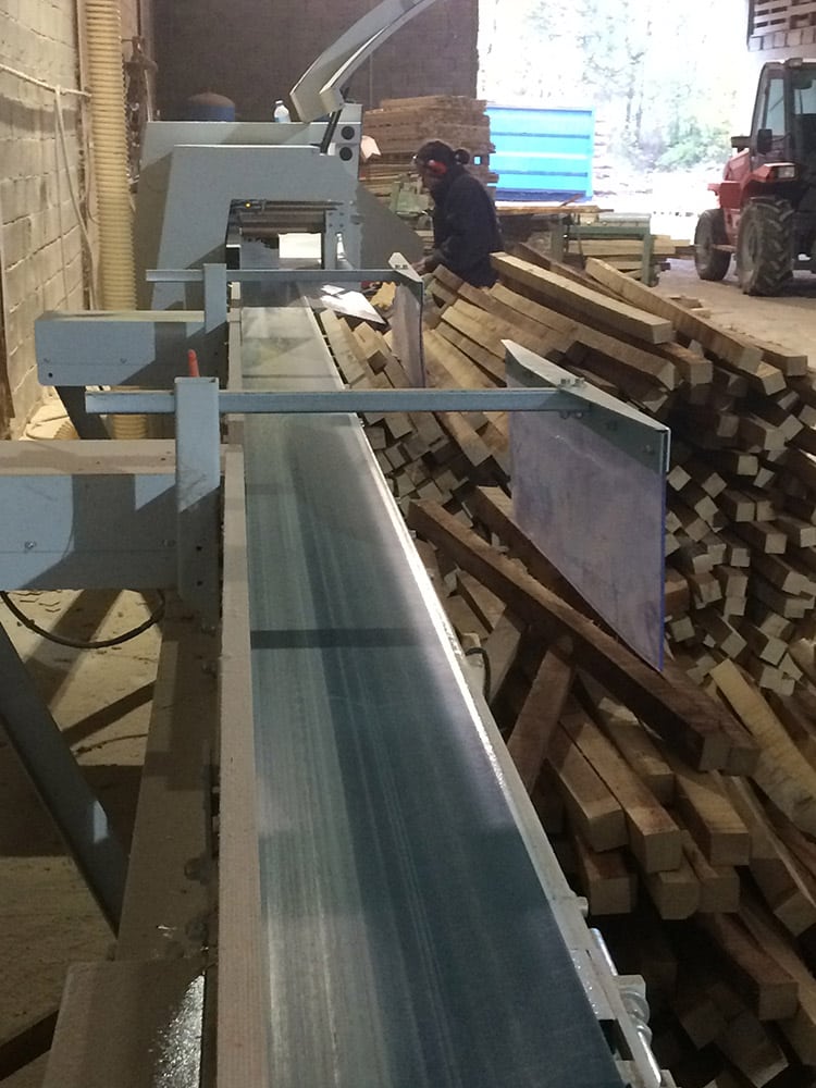Coupe des troncs de bois massif servant à la fabrication de nos tables