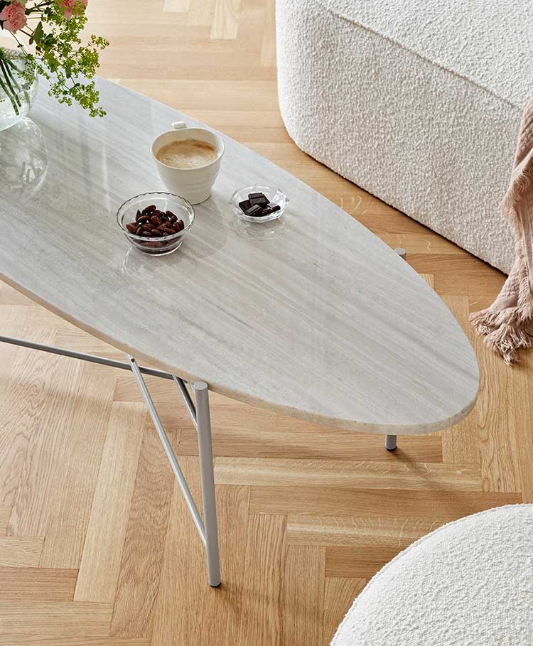 Table basse avec plateau en marbre ovale de couleur claire et pied en acier gris clair