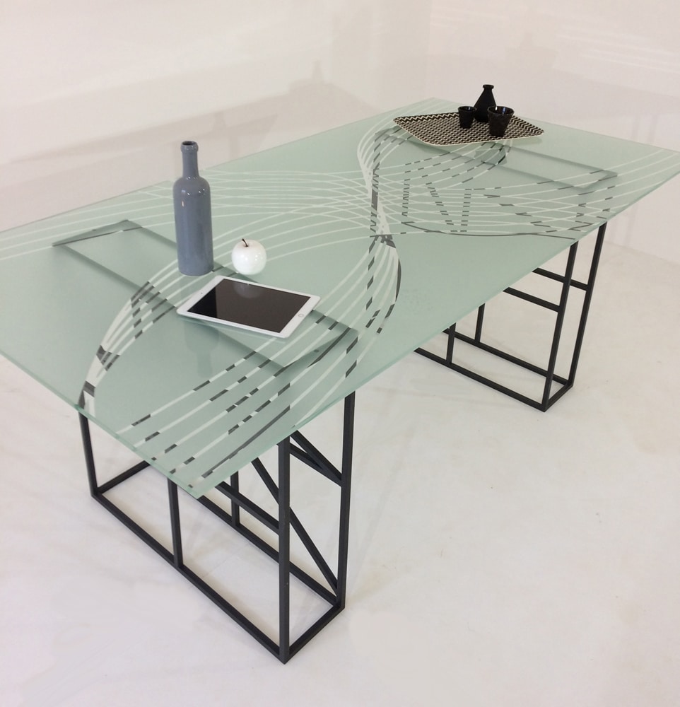 La table DESILIA avec pieds en métal au design original et plateau en verre trempé sablé de motifs originaux.