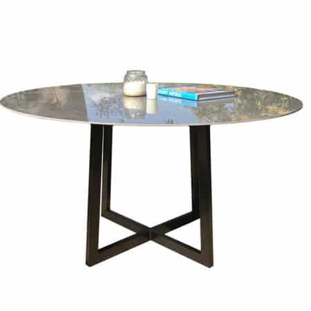 table à manger avec plateau en céramique imitation marbre et pied en acier noir thermolaqué, de forme trapèze.