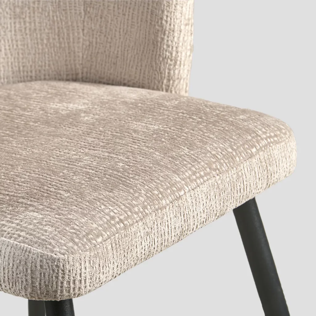 détail de l'assise de la chaise qui met en évidence le tissu beige légèrement gaufré.