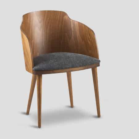 chaise de table confortable en bois massif avec dossier arrondi et accoudoirs galbés dans le prolongement du dossier.