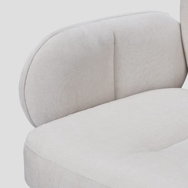 Détail de l'accoudoir et de l'assise en tissu blanc du fauteuil de table