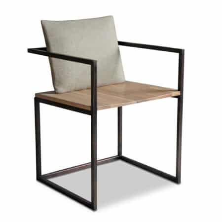 chaise de table avec accoudoirs au style Industriel Chic, avec assise en chêne naturel, cadre en acier et coussin en tissu clair.