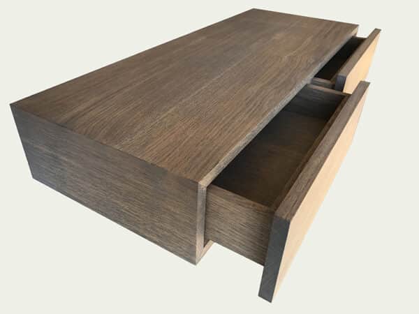 Détail des tiroirs avec finition grisée du meuble console d'entrée en chêne et métal avec tiroirs et étagère.